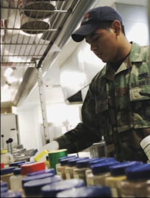Airman Jesus Ramirez, 22nd Services Squadron chef, gathers ingredients from the spice rack to prepare cornmeal dressing for one of the lunch meals. (U.S. Air Force photo/Master Sgt. Maurice Hessel)