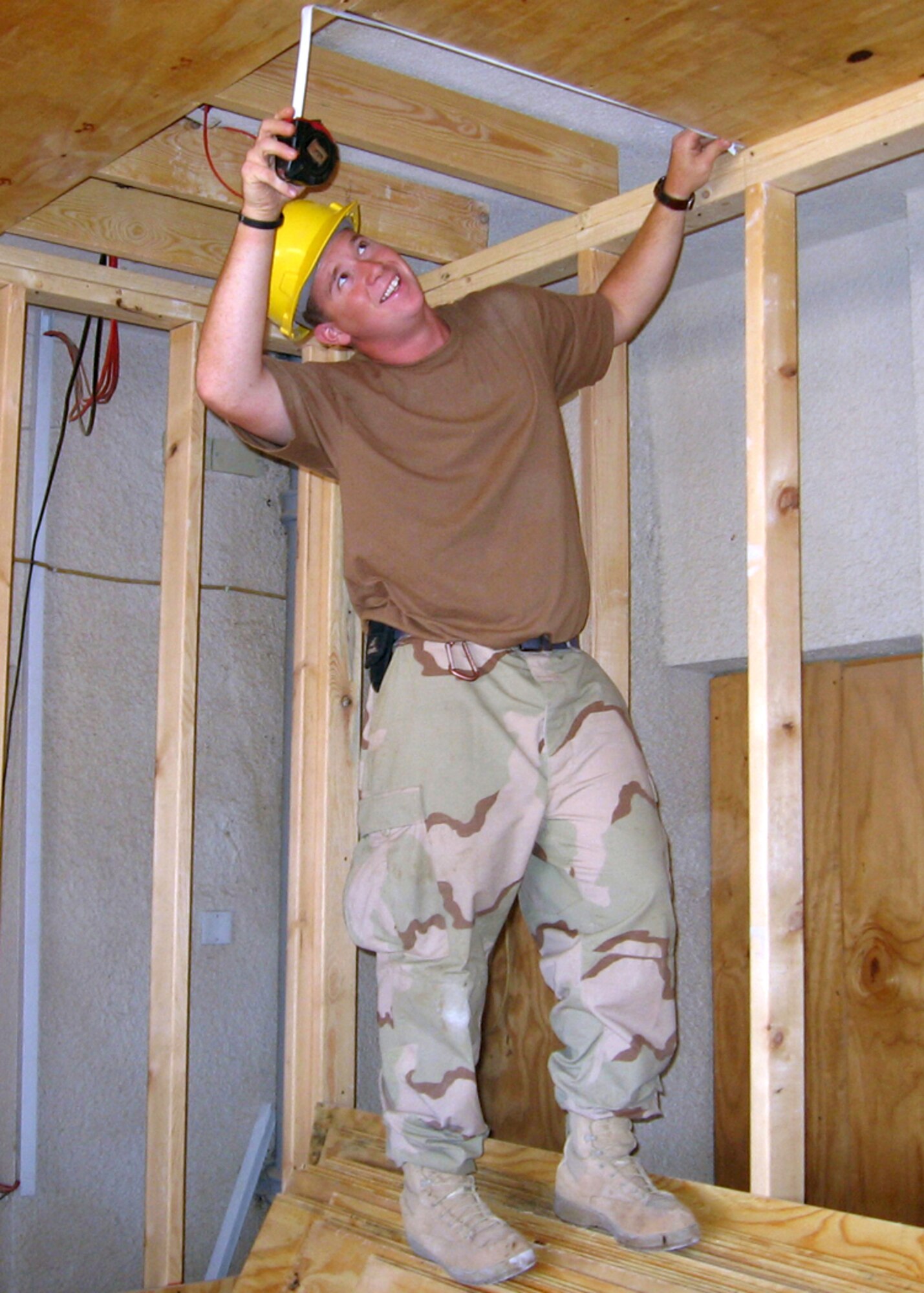 Airman 1st Class Fred Adams takes measurements for plywood to complete a ceiling for a tactical operations center expansion project at a forward operating base in Iraq on Monday, July 17. Airman Adams is deployed to the 732nd Expeditionary Civil Engineer Squadron's Detachment 10. (Courtesy photo)