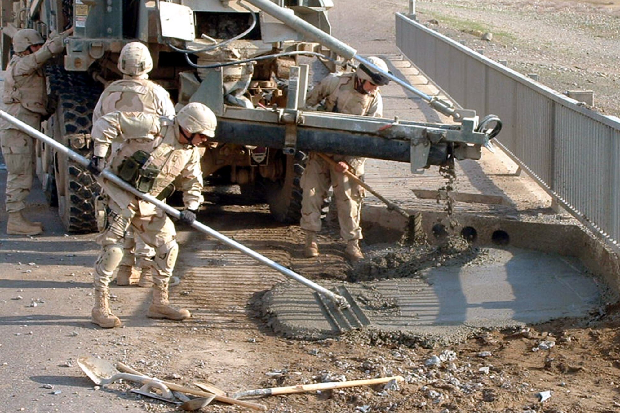 Airmen fill in a crater caused by an improvised explosive device on Monday, July 17, in Iraq. Members of the 732nd Expeditionary Civil Engineer Squadron's Detachment 10 are frequently called upon to repair damage to convoy routes caused by IEDs. (Courtesy photo)