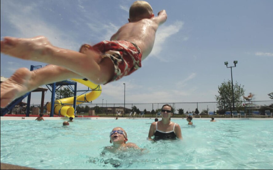 Braxton Todd, 3, son of Capt. Troy Todd, 22nd Medical Operations Squadron, jumps into the McConnell outdoor pool, while his mother, Terrilynn, and brother, Cameron, 5, watch on June 29. The pool is a great way for the family to cool off during this hot summer weather. (U.S. Air Force photo/Master Sgt. Maurice Hessel)