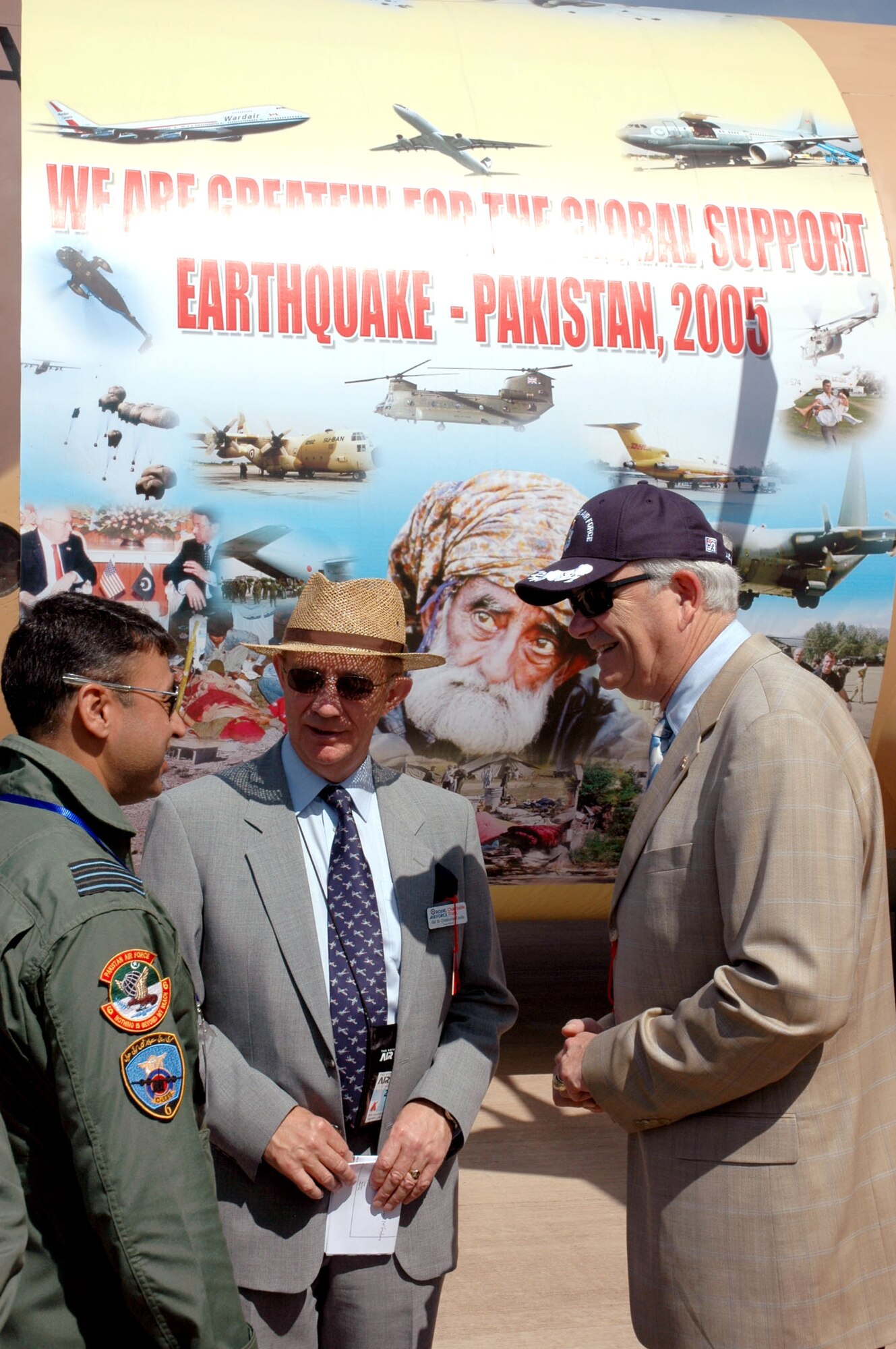 Secretary of the Air Force Michael W. Wynne (right) and Sir Christopher Coville (center) talk with Wing Cmdr. Haseeb Gul from the Pakistan Air Force during the Royal International Air Tattoo in England. Commander Gul said the Pakistani airmen attended the air show as a way of saying "thank you" for the global support their country received after a devastating earthquake in October that killed more than 73,000 people. (U.S. Air Force photo/Master Sgt. Chuck Roberts)
