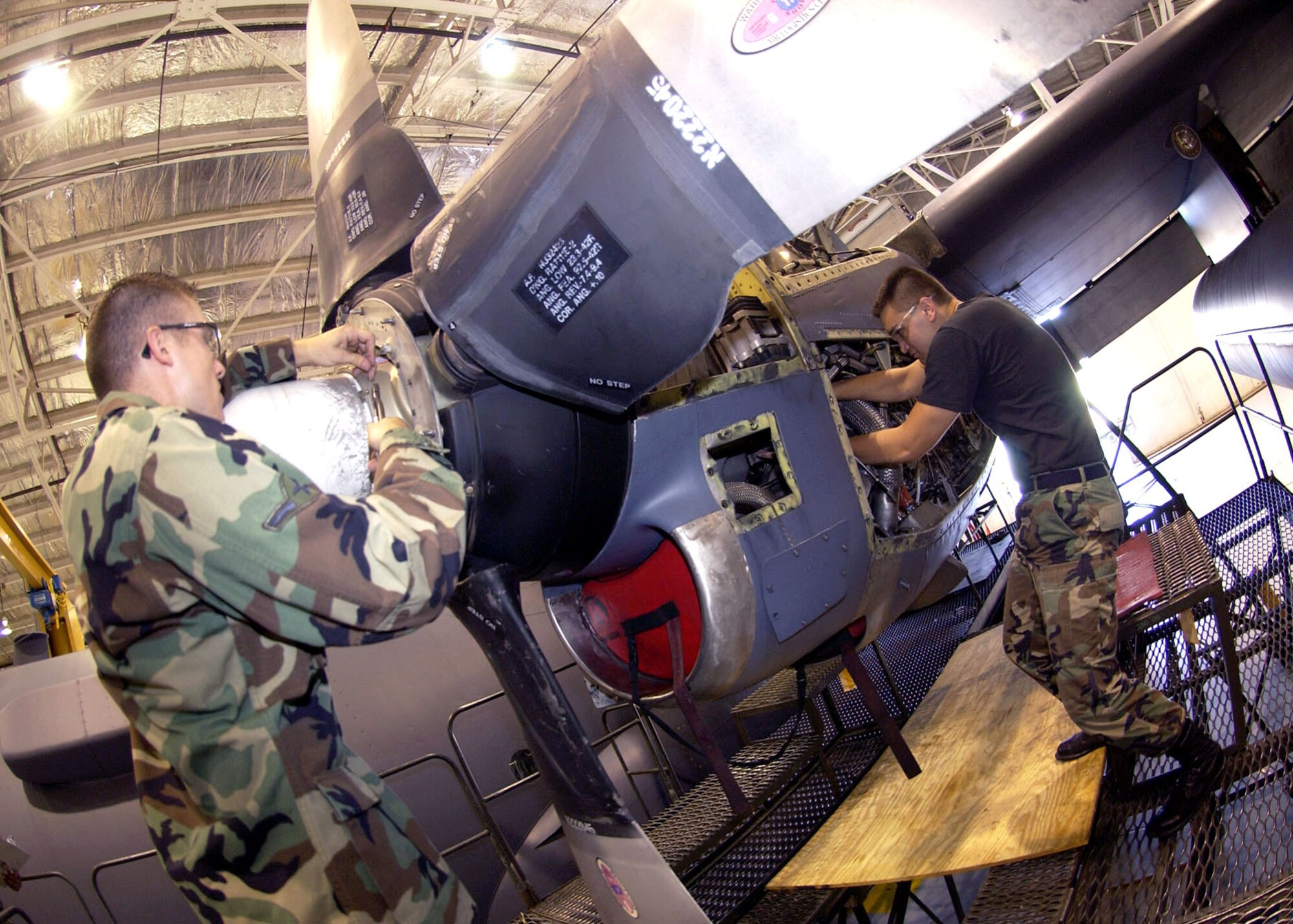 Airman Nick Sinwell installs safety wire on the dome of an EC-130 Compass Call propeller while Staff Sgt. Sam Gaare tightens a drain valve on the engine at Davis-Monthan Air Force Base, Ariz., on July 18. Both Airmen are assigned to the 355th Equipment Maintenance Squadron. (U.S. Air Force photo/Airman 1st Class Veronica Pierce)
