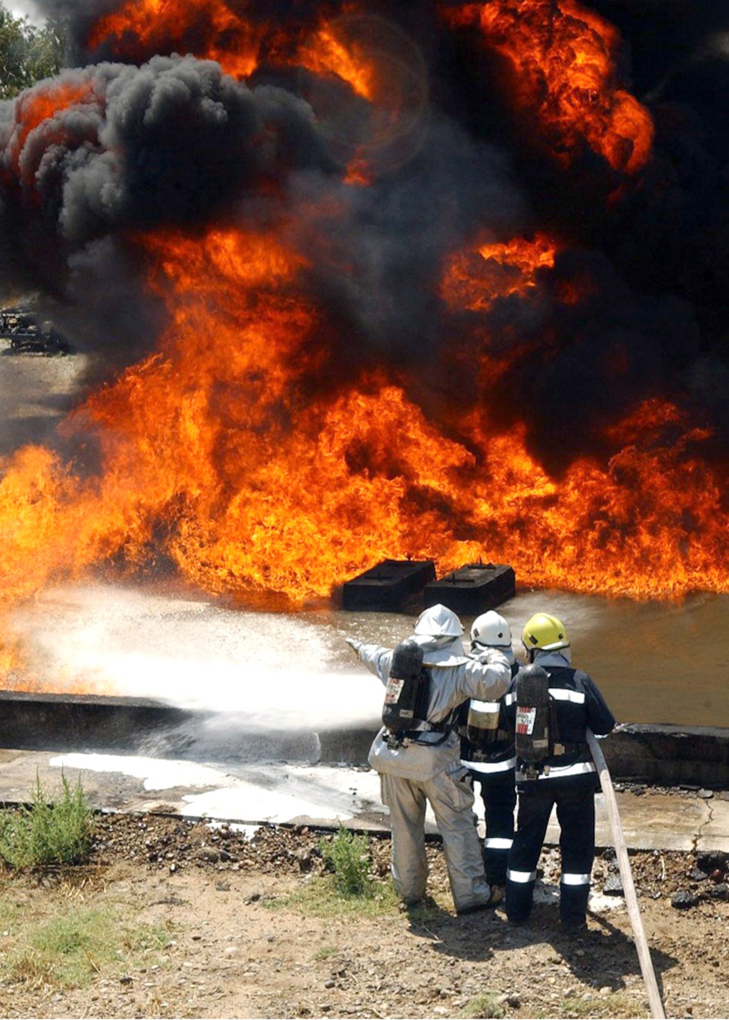 Firefighters from the 506th Expeditionary Civil Engineer Squadron and the Iraqi Air Force battle a pit fire during training at Kirkuk Air Base, Iraq. (U.S. Air Force photo/Senior Airman Angelita Collins)