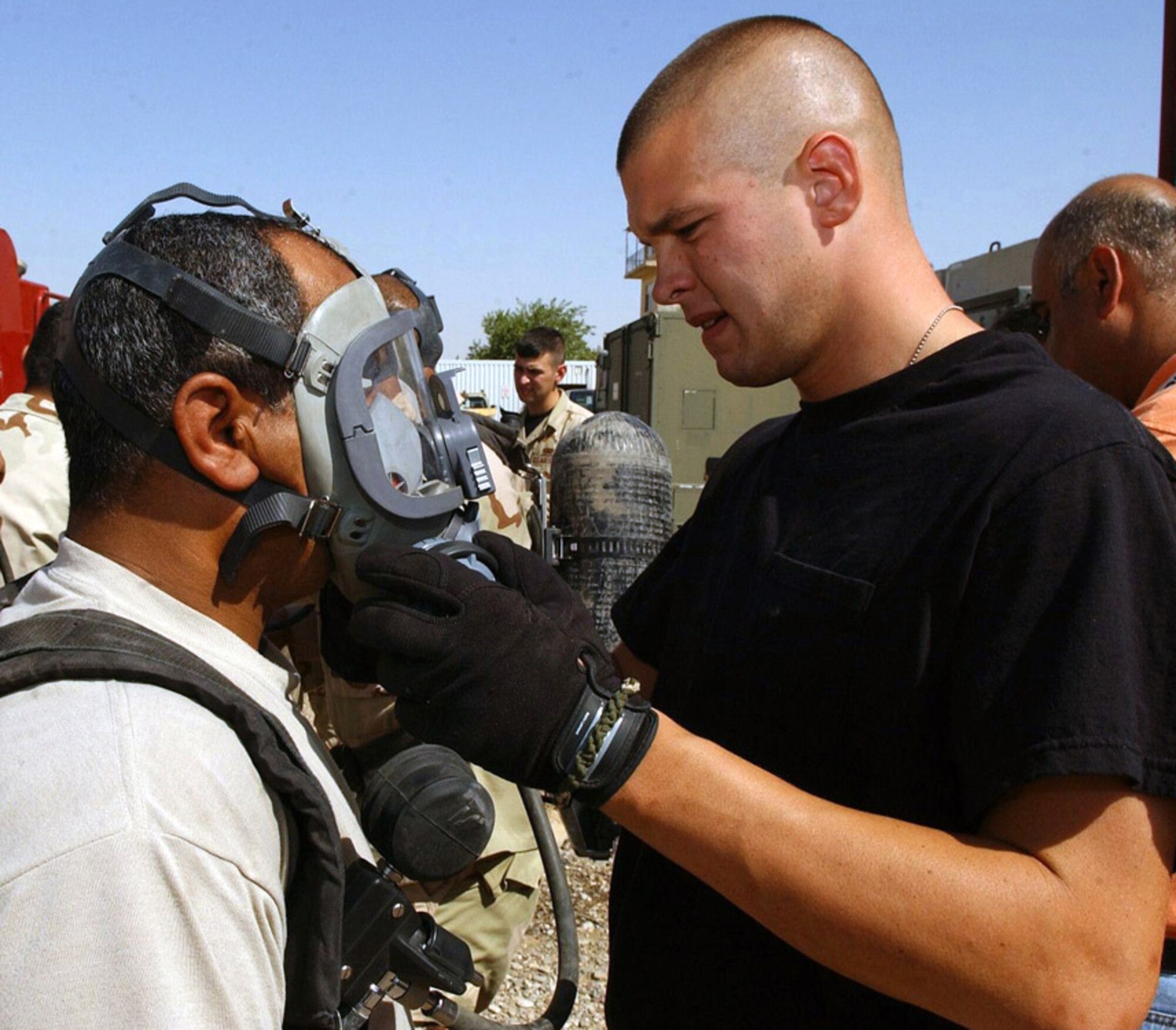 Senior Airman Bradley Hillebrand checks an Iraqi firefighter's face mask for a proper seal during training at Kirkuk Air Base, Iraq. Air Force firefighters are training Iraqi Air Force volunteer firefighters on the principles of firefighting and using protective gear. Airman Hillebrand is with the 506th Expeditionary Civil Engineer Squadron fire department. (U.S. Air Force photo/Senior Airman Angelita Collins)