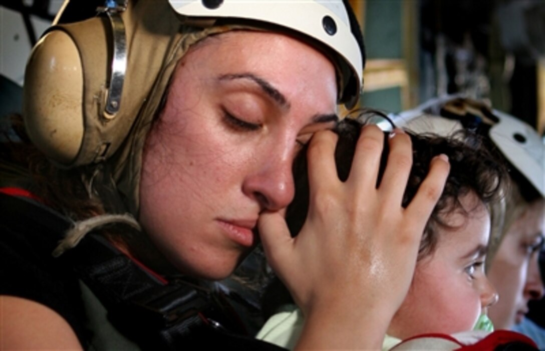 An American woman calms a child while traveling in a U.S. Marine Corps CH-53 Super Stallion helicopter to Cyprus following their departure from the U.S. Embassy in Beirut, Lebanon, July 18, 2006.
