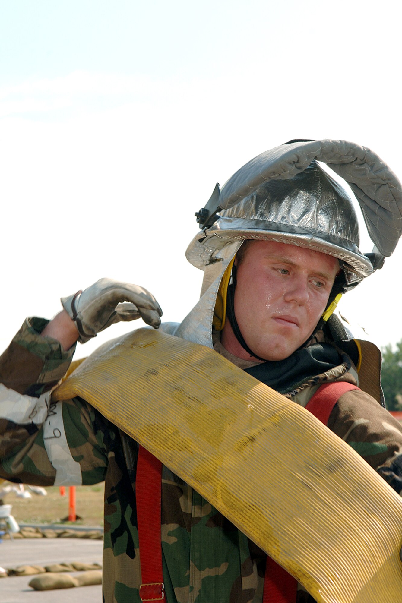 Airman 1st Class Lance Brozik reels in a water hose after a simulated fire at Ellsworth Air Force Base, S.D., on July 19. The scenario was part of an operational readiness inspection. Airman Brozik is with the 28th Civil Engineer Squadron. (U.S. Air Force photo/Airman 1st Class Melissa Flores)