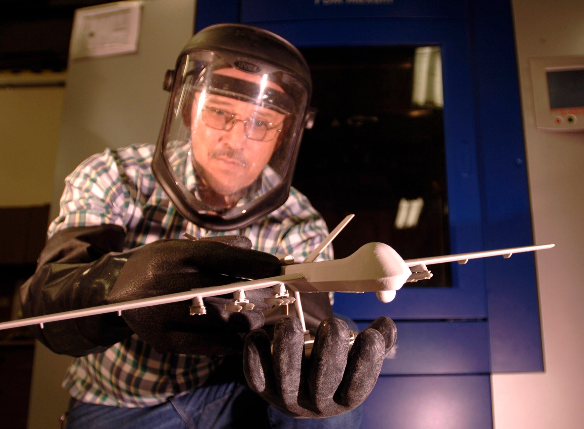 Bud Schmidt holds a model of an unmanned aerial vehicle created by the Fused Deposition Modeler at Sheppard Air Force Base, Texas, on Wednesday, July 19. The modeler creates 3-D, solid models using polycarbonate, synthetic plastic, wax and other materials to build durable, fully functional trainers that can range from an aircraft engine or landing gear to a mold of teeth. Mr. Schmidt is a fabrication supervisor for the 982nd Maintenance Squadron. (U.S. Air Force photo/Tech. Sgt. Cecilio M. Ricardo Jr.)