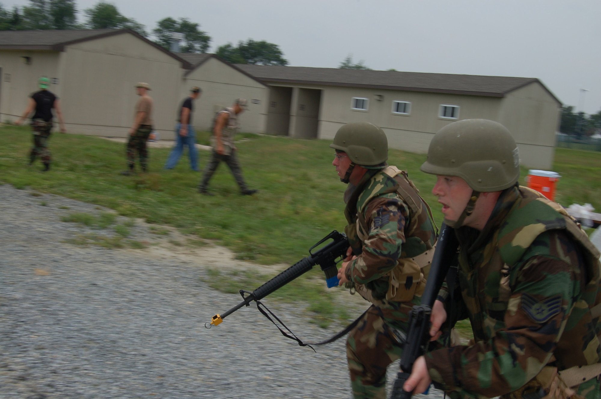 Staff Sgt. Michiel Perrault Jr. (left), 436th Services Squadron, and Staff Sgt. Jay Bennett, 436th Operations Support Squadron, rush to defend their positions against insurgents during the Expeditionary Combat Skills Training course here July 13. ECST consists of a minimum of 19 hours of training divided between classroom instruction and “hands-on” field training. (U.S. Air Force photo/Staff Sgt. James Wilkinson)