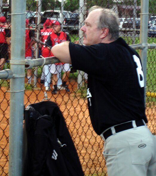 Larry "Hoppy" Hopkins watches an intramural softball game from his team's dugout at Homestead Air Reserve Base, Fla.  Hoppy is the pitcher for the 482nd Security Forces intramural softball team.  He works as a Deparment of Defense Police Officer a the base and has been playing softball here for 25 years (Air Force photo by Jake Shaw).