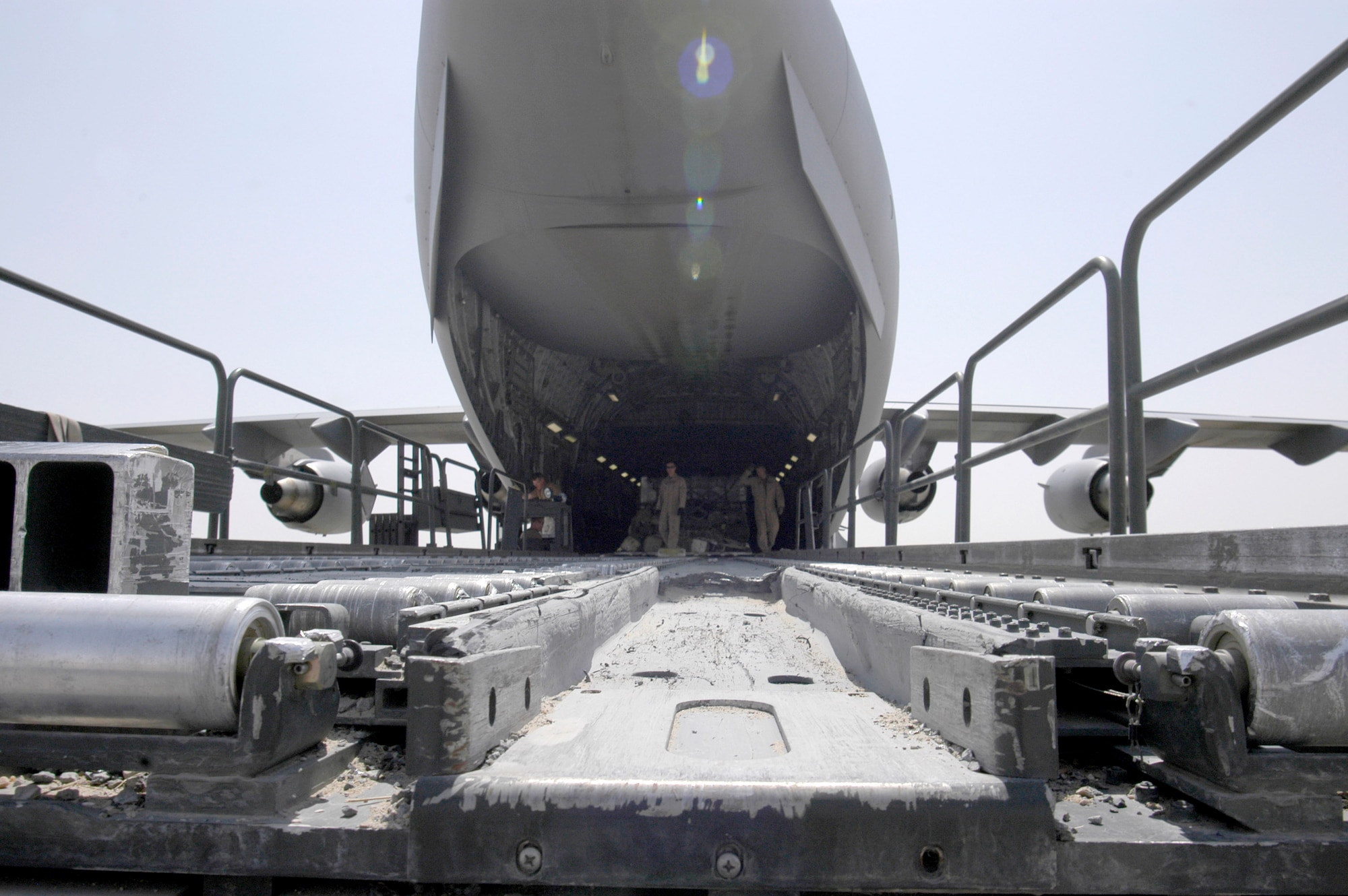 Loadmasters for a C-17 Globemaster III finish loading cargo on Wednesday, July 19, at a forward operating base in Southwest Asia. During the past month, Air Force C-130 Hercules and C-17 aircraft transiting this base have increased airlift operations to move armored vehicles, repair parts and ammunition to Soldiers and Airmen in Iraq. (U.S. Air Force photo/Major Thomas Crosson)