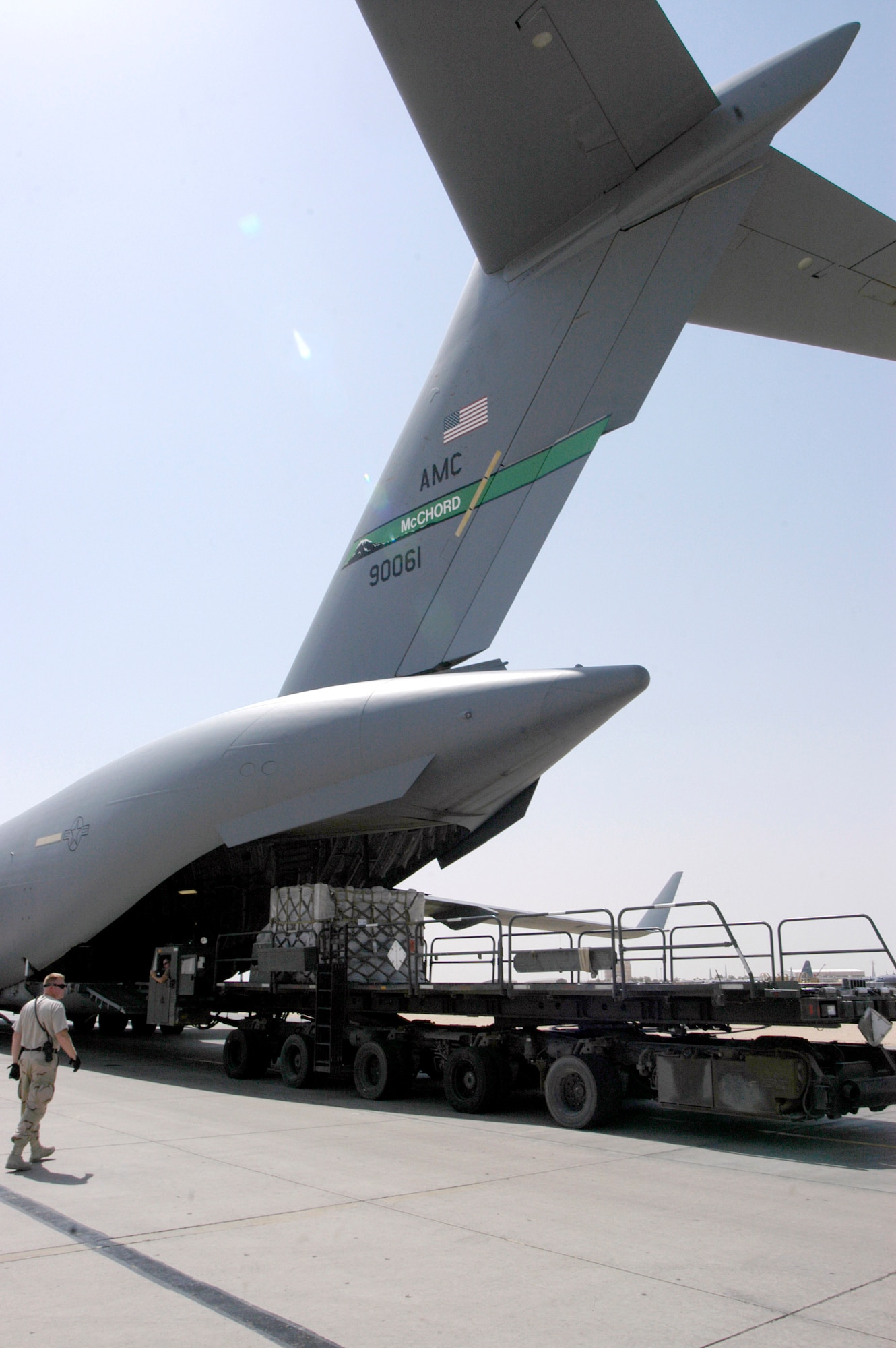 Tech. Sgt. Mark Harris monitors cargo being loaded on a C-17 Globemaster III on Wednesday, July 19, at a forward operating base in Southwest Asia. The 386th Expeditionary Logistics Readiness Squadron Aerial Port Flight is responsible for receiving, accounting for and moving passengers and cargo in and out of the base. It moved more than 20,000 tons of cargo since the beginning of 2006, almost double what it moved in the first half of 2005. Sergeant Harris is a ramp team shift supervisor with the 386th ELRS. (U.S. Air Force photo/Major Thomas Crosson)