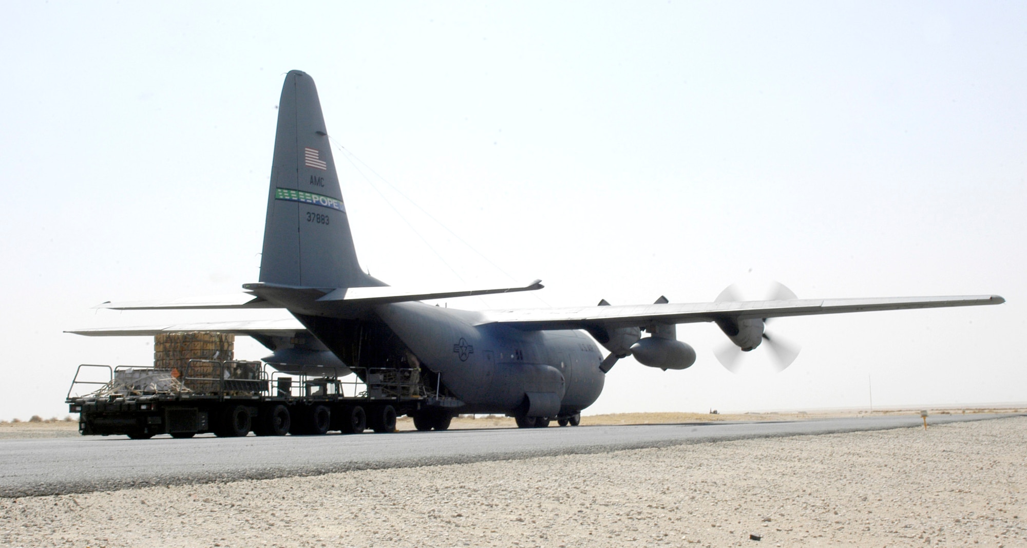 Airmen from the 386th Expeditionary Logistics Readiness Squadron Aerial Port Flight conduct an engine running offload on a C-130 Hercules on Wednesday, July 19, at a forward operating base in Southwest Asia. The flight is responsible for receiving, accounting for and moving passengers and cargo in and out of the base. The aerial port flight moved more than 20,000 tons of cargo since the beginning of 2006, almost double what it moved in the first half of 2005. (U.S. Air Force photo/Major Thomas Crosson)
