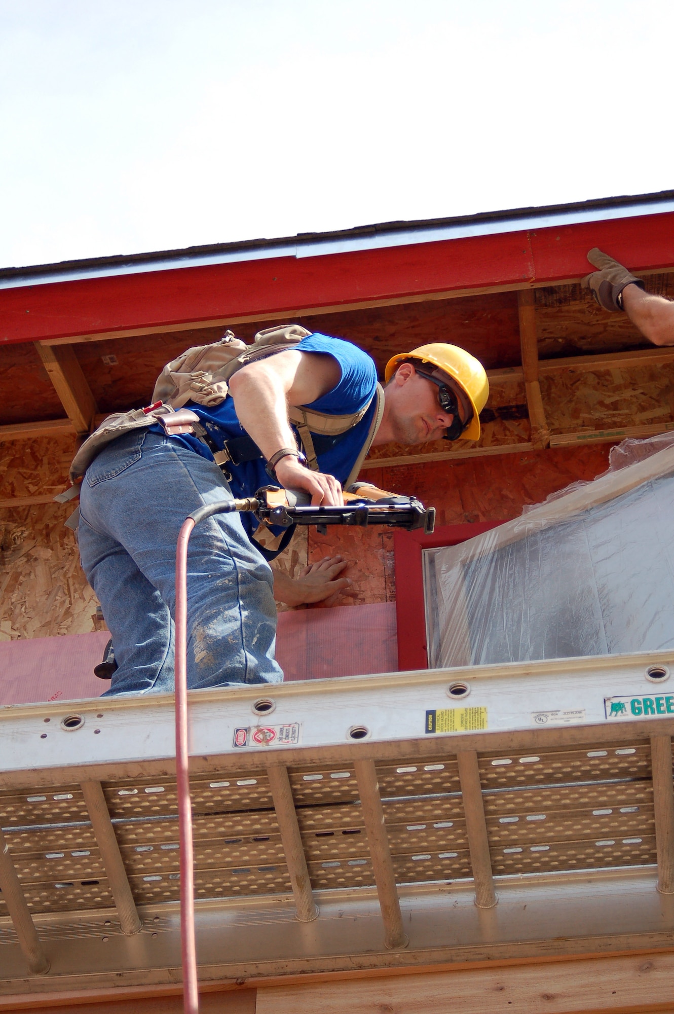 Tech. Sgt. Brenton Keay helps hang soffit on a new home built for ABC's "Extreme Makeover: Home Edition" in North Pole, Alaska. Approximately 180 military members from Elmendorf and Eielson Air Force Bases, and Forts Richardson and Wainwright helped build a house for a woman and her 12 family members. Sergeant Keay is with the 3rd Mission Support Squadron at Elmendorf. (U.S. Air Force photo/Master Sgt. Tommie Baker)