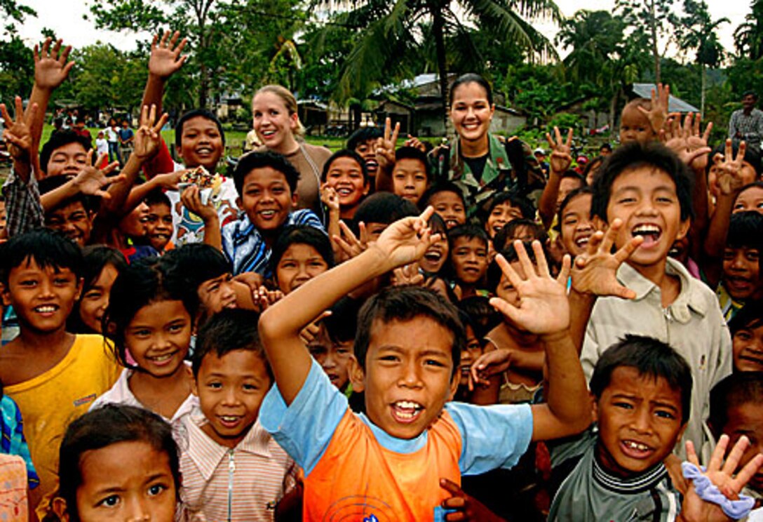 U.S. Navy Lt. Janel Rossetto, left, and U.S. Air Force Maj. Mary Ann Garbowski, play with local children during a medical civic action program conducted by the U.S. Naval hospital ship USNS Mercy during a visit to Simeulue Island, Republic of Indonesia, July 14, 2006.