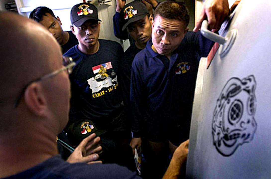 U.S. Navy Diver 1st Class David Sweeten shows a group of Indonesian ...