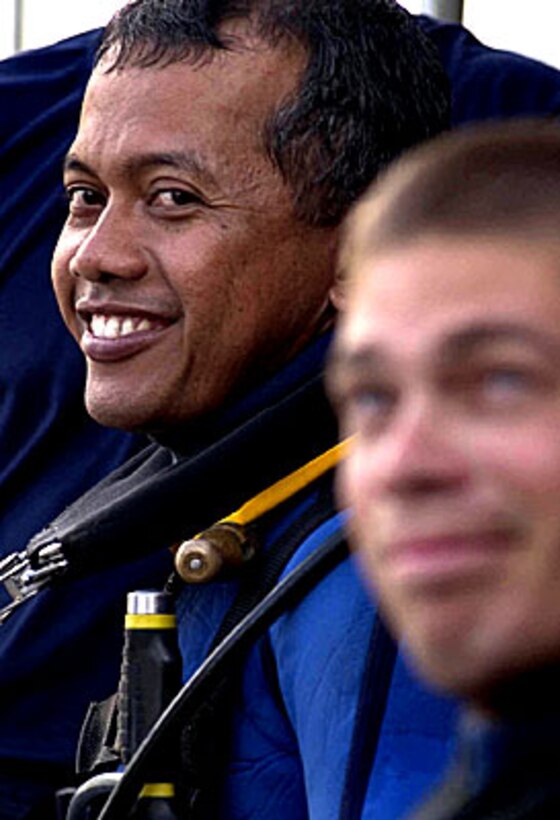 An Indonesian navy diver prepares to go on a familiarization dive with U.S. Navy Boatswain's Mate 2nd Class Christopher Timothy on the fantail of the rescue and salvage ship USS Salvor, July 14, 2006 as part of the Indonesian phase of exercise Cooperation Afloat Readiness and Training 2006.
