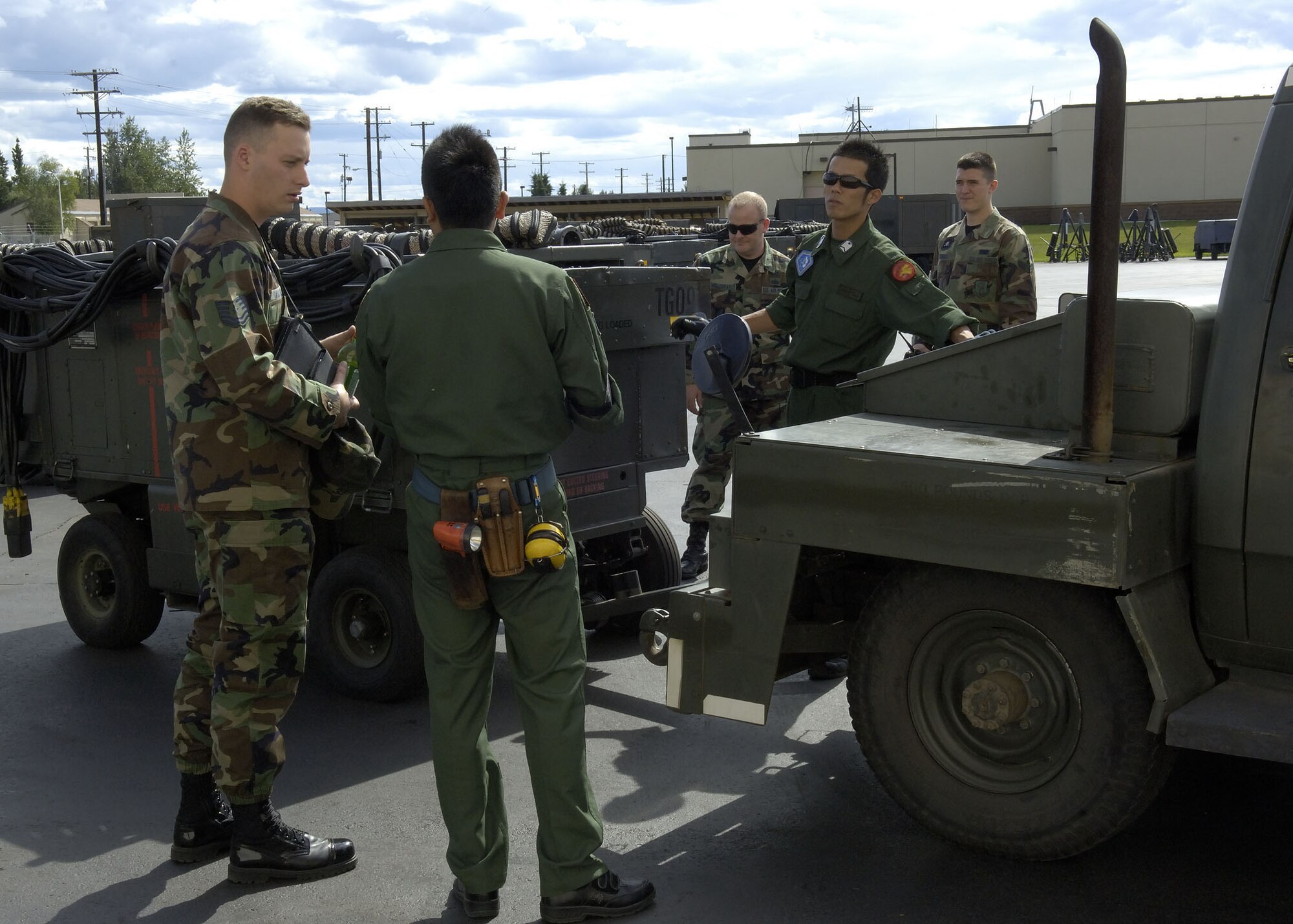 EIELSON AIR FORCE BASE, Alaska - United States Air Force (USAF) personnel assist Japan Air Self Defence Force (JASDF) with loading an aircraft auxuilary power unit onto a tow vehicle. JASDF aircraft maintainers are preparing thier F-15's for use in Excersise Co-operative Cope Thunder 06-3 (CCT06-3). Photo by Cpl J.A. Wilson, CCT06-3, Canadian Public Affairs