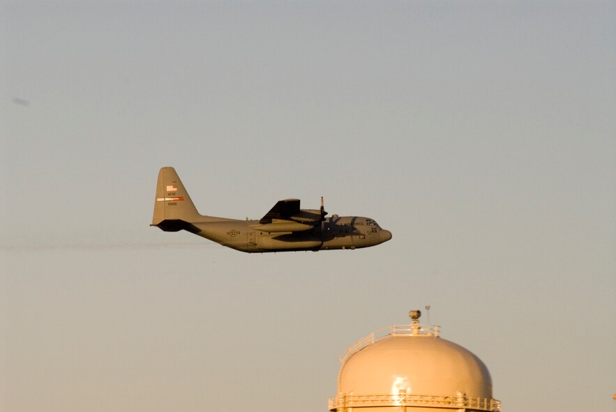 MINOT AIR FORCE BASE, N.D. -- A C-130 from the 910th Airlift Wing, Youngstown, Ohio, flys by the base water tower during an aerial mosquito spray mission Tuesday. According to base officials, the chemical, Trumpet, is very effective for the control of mosquitos yet safe to people and the environment. (Photo by Capt. James Bressendorff)
