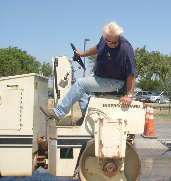 Clark Salisbury, 7th CES equipment operator, steamrolls hot asphalt.                                 