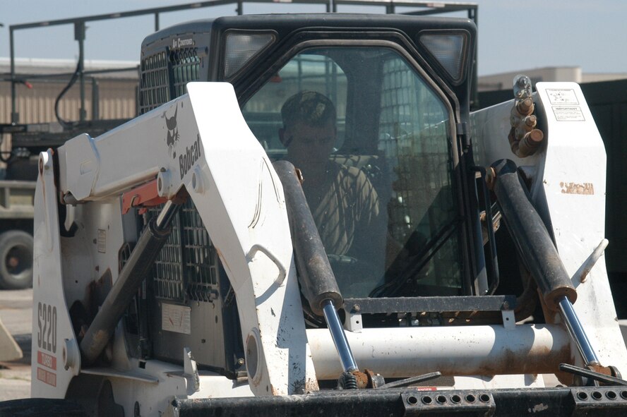 Staff Sgt. Toby Chambers, 7th Civil Engineer Squadron Dirt Boyz crew leader, prepares an area for re-pavement on base July 14. The asphalt they dump, smooth, pour and steamroll comes out at more than 400 degrees Farenheit and must be wetted down and steamrolled in order for it to set properly and hold its form.                                