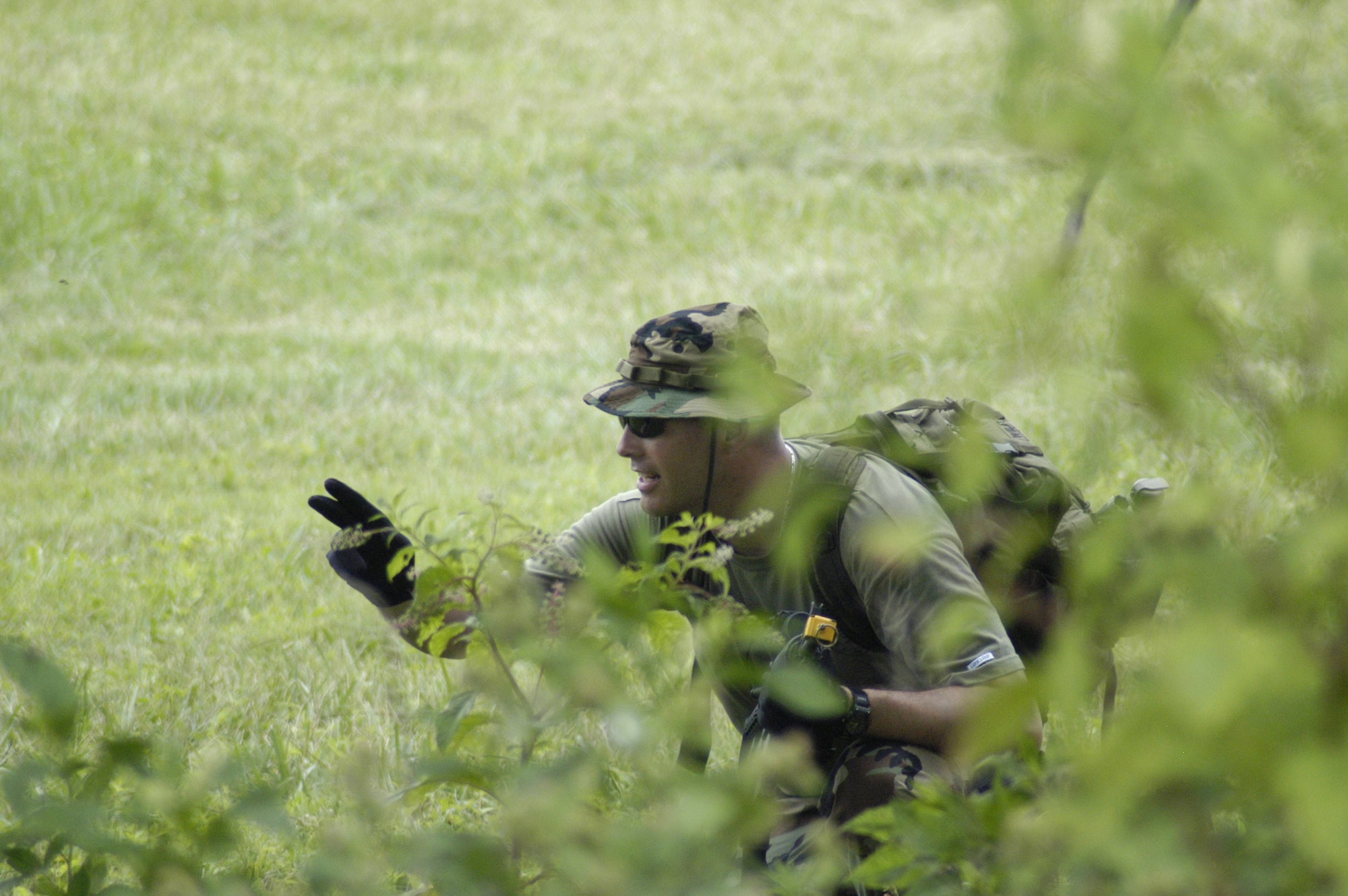 Master Sgt. Patrick Wiley, 436th Security Forces Squadron, gives hand signals to other members acting as insurgents during Expeditionary Combat Skills Training at "Base X" here July 13. Sergeant Wiley was the opposing force leader for the exercise and is the ECST logistics NCO. (U.S. Air Force photo/Airman 1st Class James Bolinger)