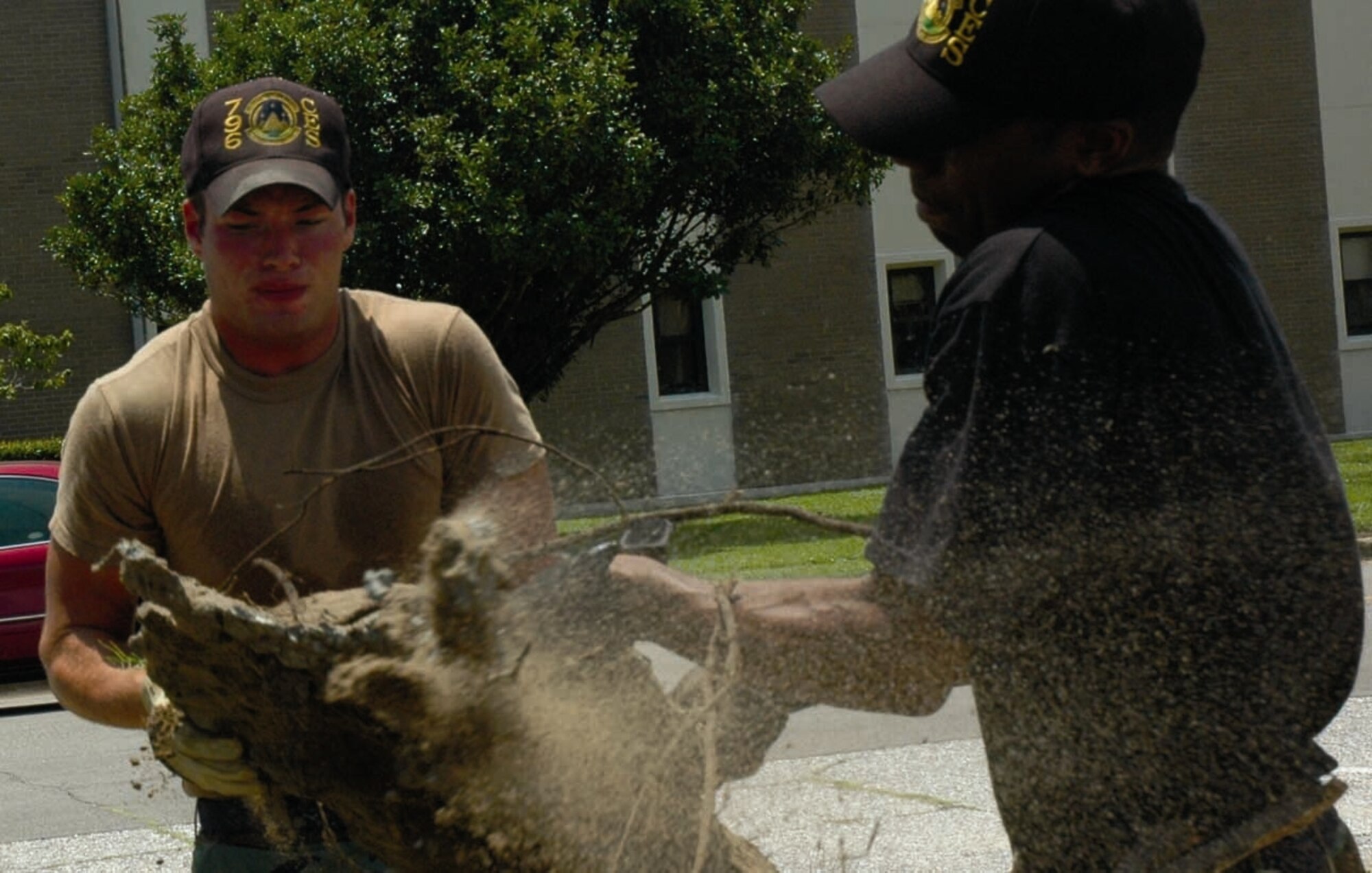 EGLIN AIR FORCE BASE, Fla. — Airman Dirk Tanses and Senior Airman Justin Simpson, 796th Civil Engineer Squadron pavement and construction equipment operators, haul dirt into a front-end loader. (Air Force photo by Maranda Rimes)

