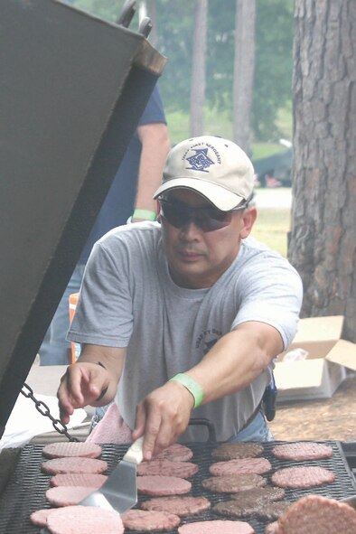 Master Sgt. Alejandro Barin, 609th Air Communications Squadron first sergeant, helps other top three members prepare food during the event July 14.   (U.S. Air Force photo/Tech. Sgt. Shirley Henderson)
