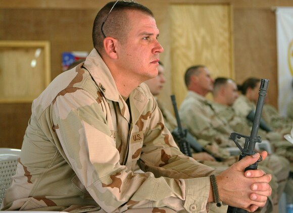 Petty Officer 1st Class Scott Seeling, a native of Green Bay, Wis., mourns one of his own, a fallen sailor, during a service July 21, 2006 for Petty Officer 1st Class Jerry A. Tharp, held at the Camp Taqaddum base chapel. Tharp, a Seabee with Naval Mobile Construction Battalion 25 and a native of Aledo, Ill., was killed in action while operating in the restive Al Anbar Province of Iraq July 12, 2006.