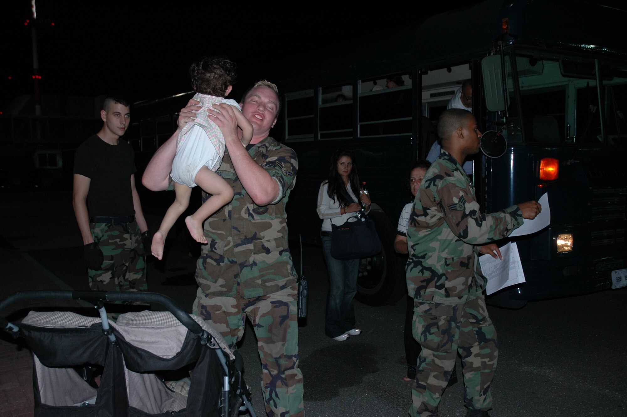 RAMSTEIN AB, Germany -- Airman 1st Class Brendan Fassl, 723rd Air Mobility Squadron Passenger Services, picks up an infant to carry onto a bus to transport American citizens displaced from Lebanon to a C-17 waiting to return them to the United States July 23.
(Photo by SMSgt Stefan Alford)