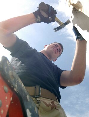 Airman 1st Class Steven Land hammers in a nail to make way for an outdoor light fixture at a field hospital run by the Egyptian Military at Bagram Airfield, Afghanistan.  Airman Land is part of the 755th Prime BEEF engineers deployed to Bagram from Kadena Air Base, Japan.  The Prime BEEF team has completed and started numerous projects while deployed to Bagram including upgrading the electrical wiring for the field hospital.  (US Air Force photo/Maj. David Kurle)
