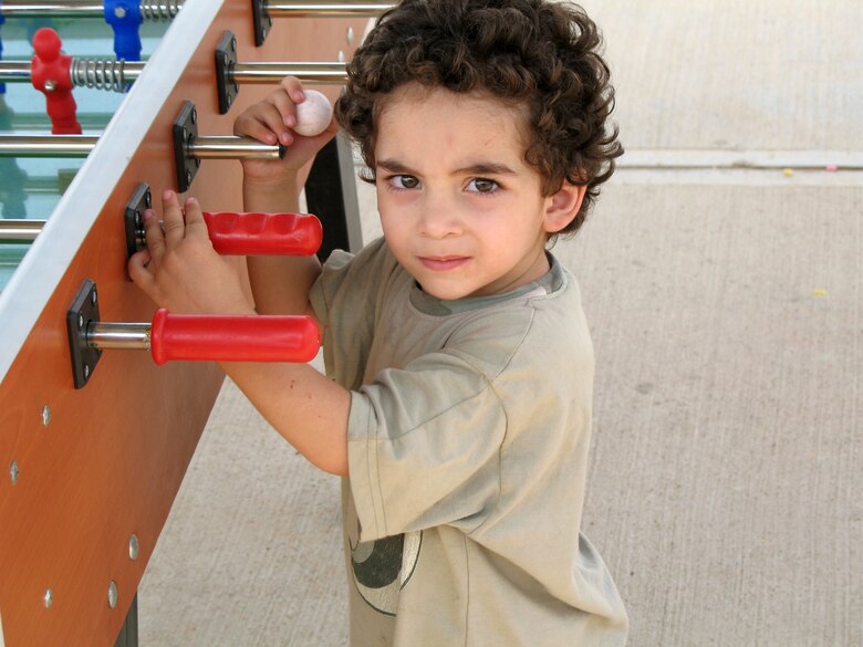 A young American who departed Lebanon plays with a foosball table at Incirlik Air Base, Turkey, on July 22. The base has provided telephones, Internet service, television, beds and showers to the displaced American citizens while they wait to travel to the United States. (U.S. Air Force photo/Master Sgt. Bob Herron)