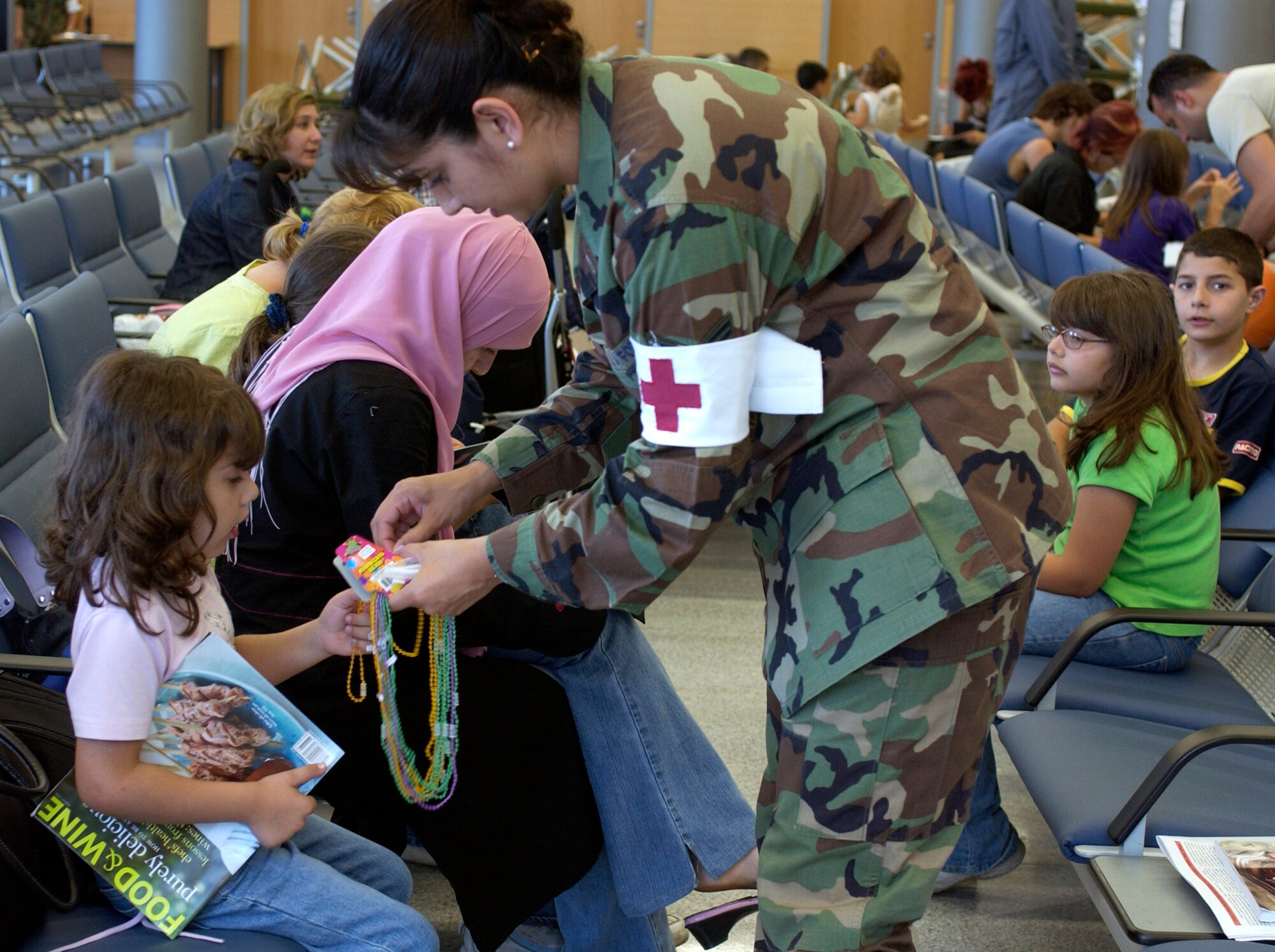 Tech. Sgt. Monica Snyder distributes candy and toys to children at the passenger terminal at Ramstein Air Base, Germany, on July 23. Airmen at Ramstein provided humanitarian assistance for American citizens departing the Lebanon crisis on their way to the United States. Sergeant Snyder is with the 435th Medical Group. (U.S. Air Force photo/Staff Sgt. Angela B. Malek)