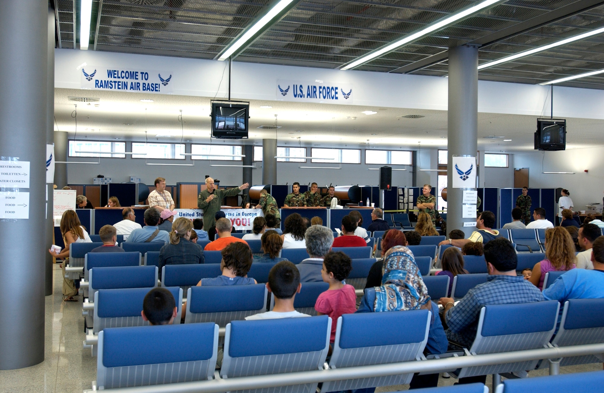 Departees from Lebanon are briefed by Col. Glen Apgar at the passenger terminal on Ramstein Air Base, Germany on July 23. Airmen at Ramstein provided humanitarian assistance for American citizens departing the Lebanon crisis on their way to the United States. Colonel Apgar is vice commander of the 86th Airlift Wing. (U.S. Air Force photo/Staff Sgt. Angela B. Malek)