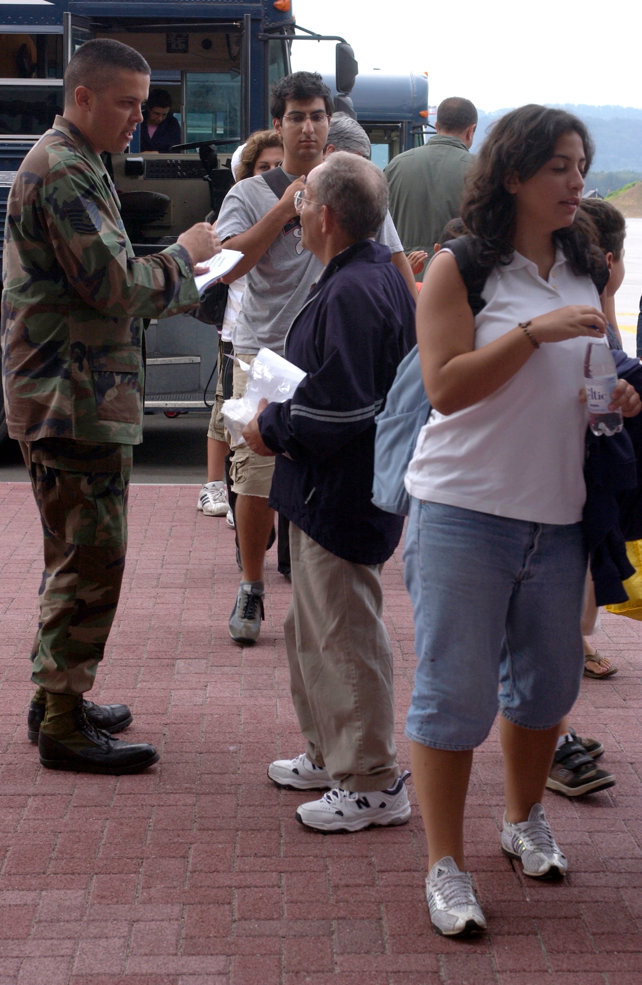 Tech. Sgt. John Holodnick gives a customs processing sheet to David Kazzi of Norfolk, Va., outside the passenger terminal at Ramstein Air Base, Germany, on July 23. Mr. Kazzi was one of several American citizens departing the crisis in Lebanon. They Americans were provided humanitarian assistance on their way to the United States by Airmen at Ramstein. Sergeant Holodnick is with the 435th Logistics Readiness Squadron. (U.S. Air Force photo/Staff Sgt. Angela B. Malek)