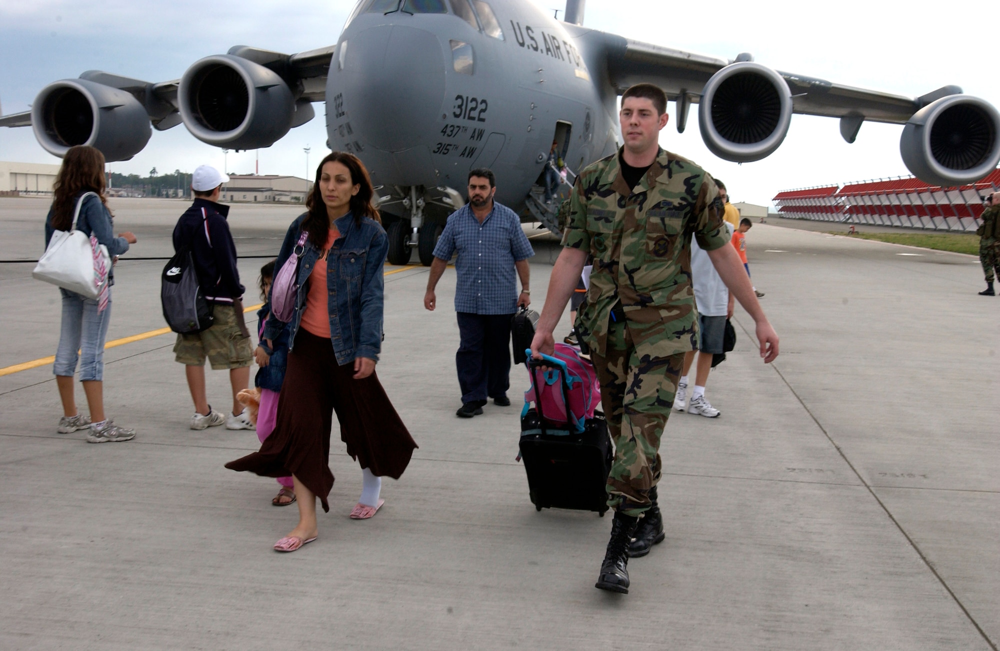 Senior Airman Benjamin Schmidt assists an American citizen with her luggage at Ramstein Air Base, Germany, on July 23. Ramstein Airmen provided humanitarian assistance for Americans departing the Lebanon crisis on their way to the United States. Airman Schmidt is with the 723rd Air Mobility Squadron. (U.S. Air Force photo/Staff Sgt. Angela B. Malek) 