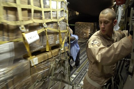 Senior Airman Donnie McCorkle waits to lock a pallet in place as ground crew personnel in Southwest Asia help load a C-17 Globemaster III on July 22. C-17 Globemaster III crews from the 816th Expeditionary Airlift Squadron are filling their cabins with pallets of supplies such as water, Meals, Ready to Eat and cots for the American citizens leaving Lebanon. This C-17 transported 17 pallets, about 64,000 pounds, of cargo to Cyprus on this mission. Airman McCorkle is a loadmaster with the 816th EAS. (U.S. Air Force photo/Senior Airman Brian Ferguson) 