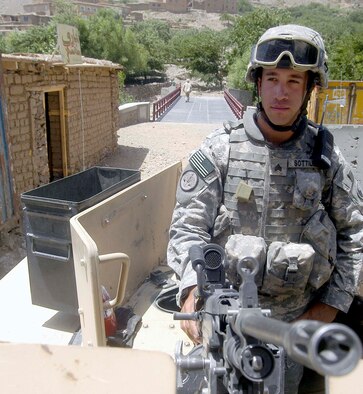 Army Sgt. Michael Sottile stands guard with an M-249 squad automatic weapon in the turret of an armored HUMVEE providing security for the opening of a bridge in Parwan Province, Afghanistan.  Sergeant Sottile, from the Connecticut National Guard, is a member of the Bagram Provincial Reconstruction team which is performing security, interfacing with the Parwan government and leading reconstruction efforts.  (US Air Force photo/Maj. David Kurle)