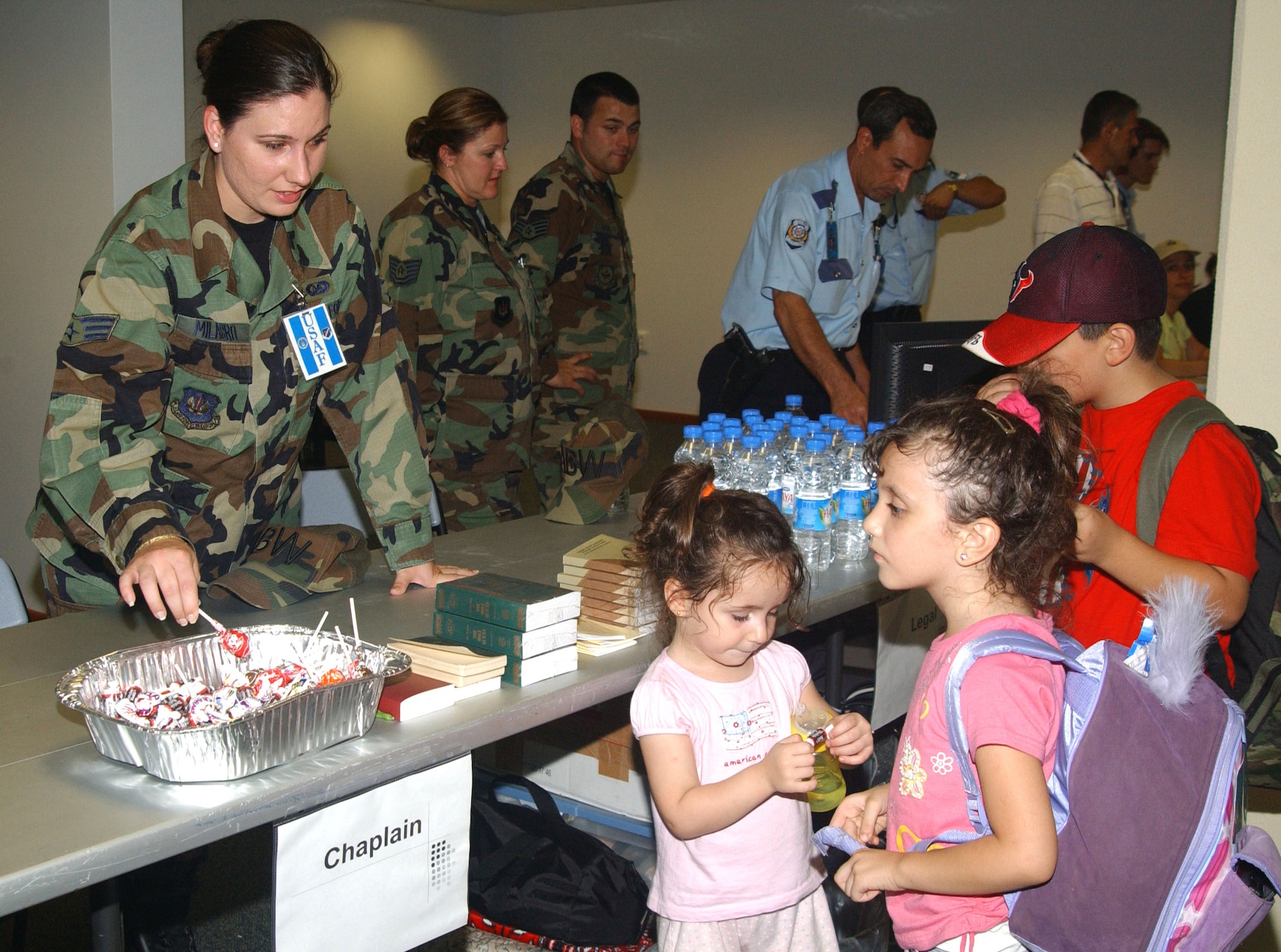 Senior Airman Tianna Milagro offers candy to children arriving at Incirlik Air Base, Turkey, on July 24. The children are among the Americans who left Lebanon and were transiting Turkey on their way to the United States. Airman Milagro is assigned to the 39th Air Base Wing. (U.S. Air Force photo/Airman Kelly L. Flynn)              