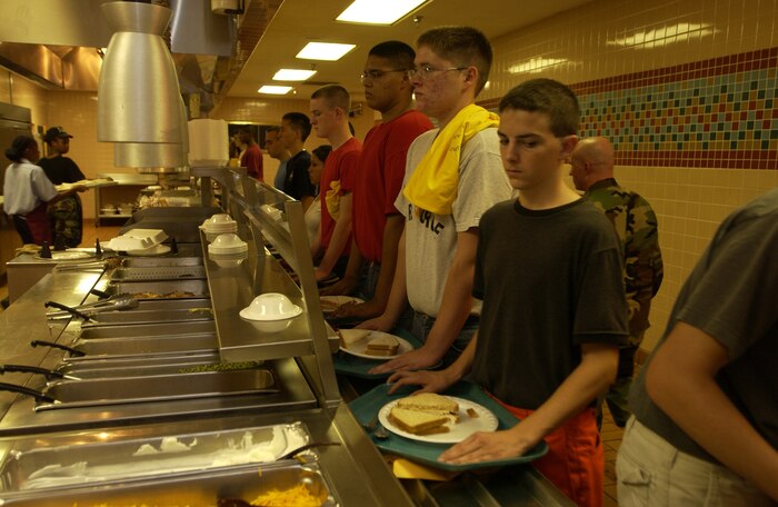 Cadets stand at attention Wednesday while getting lunch at the dining facility.  Air Force Junior Reserve Officer Training Corps cadets  are at Nellis AFB, Nev., to get some military experience during the summer break. Nellis Airmen volunteer as military training instructors. (Air Force photo/Airman 1st Class Jason Huddleston)