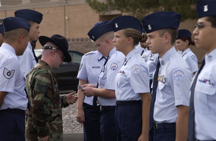 A cadet hands over a "341" to his instructor after failing to pass inspection Wednesday. The infamous "341" is an excellence or discrepancy report. Air Force Junior Reserve Officer Training Corps cadets  are at Nellis AFB, Nev., to get some military experience during the summer break. Nellis Airmen volunteer as military training instructors. (Air Force photo/Airman 1st Class Jason Huddleston)