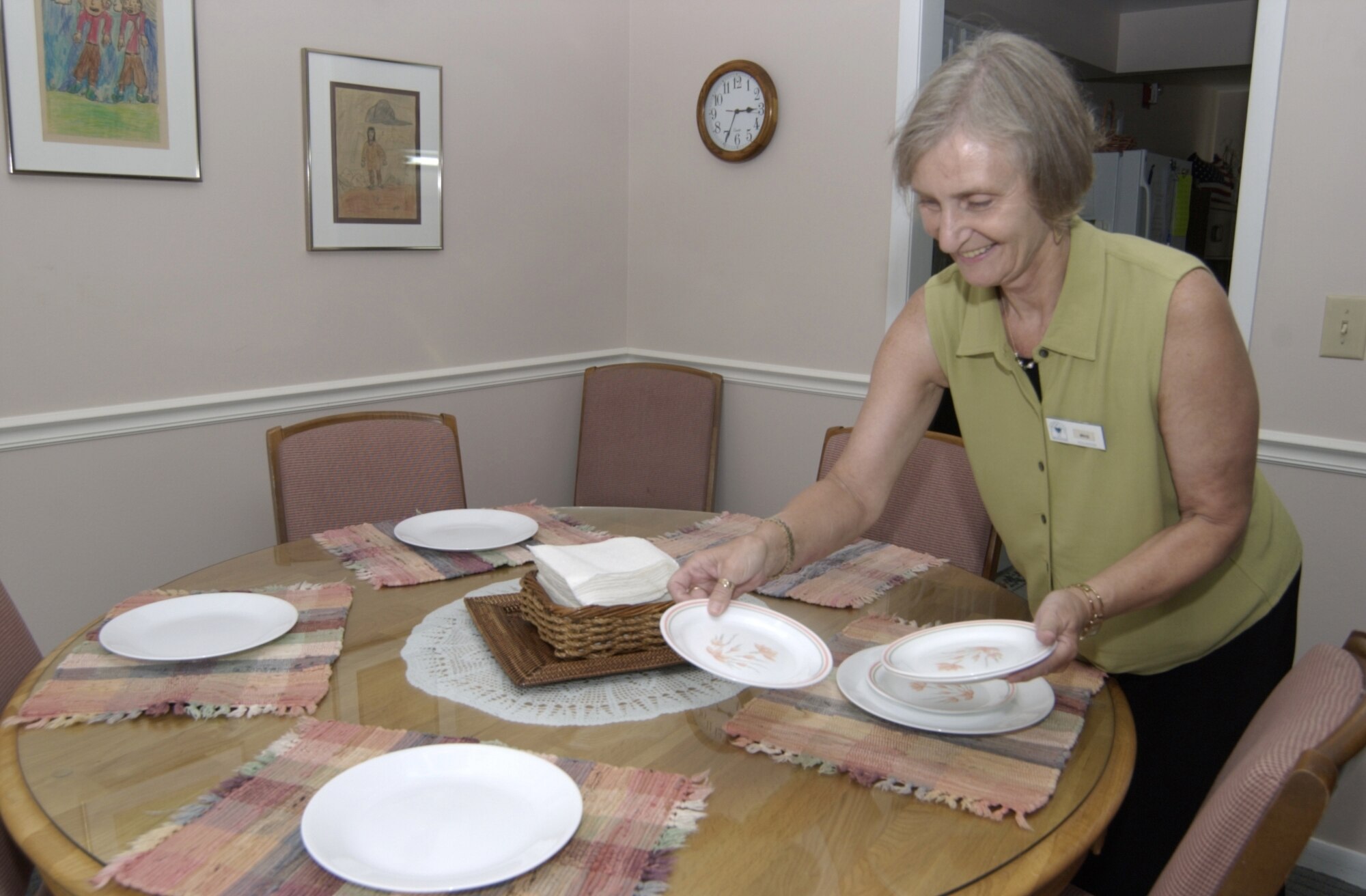 WRIGHT-PATTERSON AIR FORCE BASE, Ohio — Iris Solomon sets a table for four at the Nightingale House July 19. She has been a volunteer at the base compassionate care facility for nearly a year. Ms. Solomon volunteered at the Fisher House at Andrews AFB, Md., where her husband, Col. Otha Solomon, was the dental squadron commander. (Air Force photo by Spencer P. Lane)