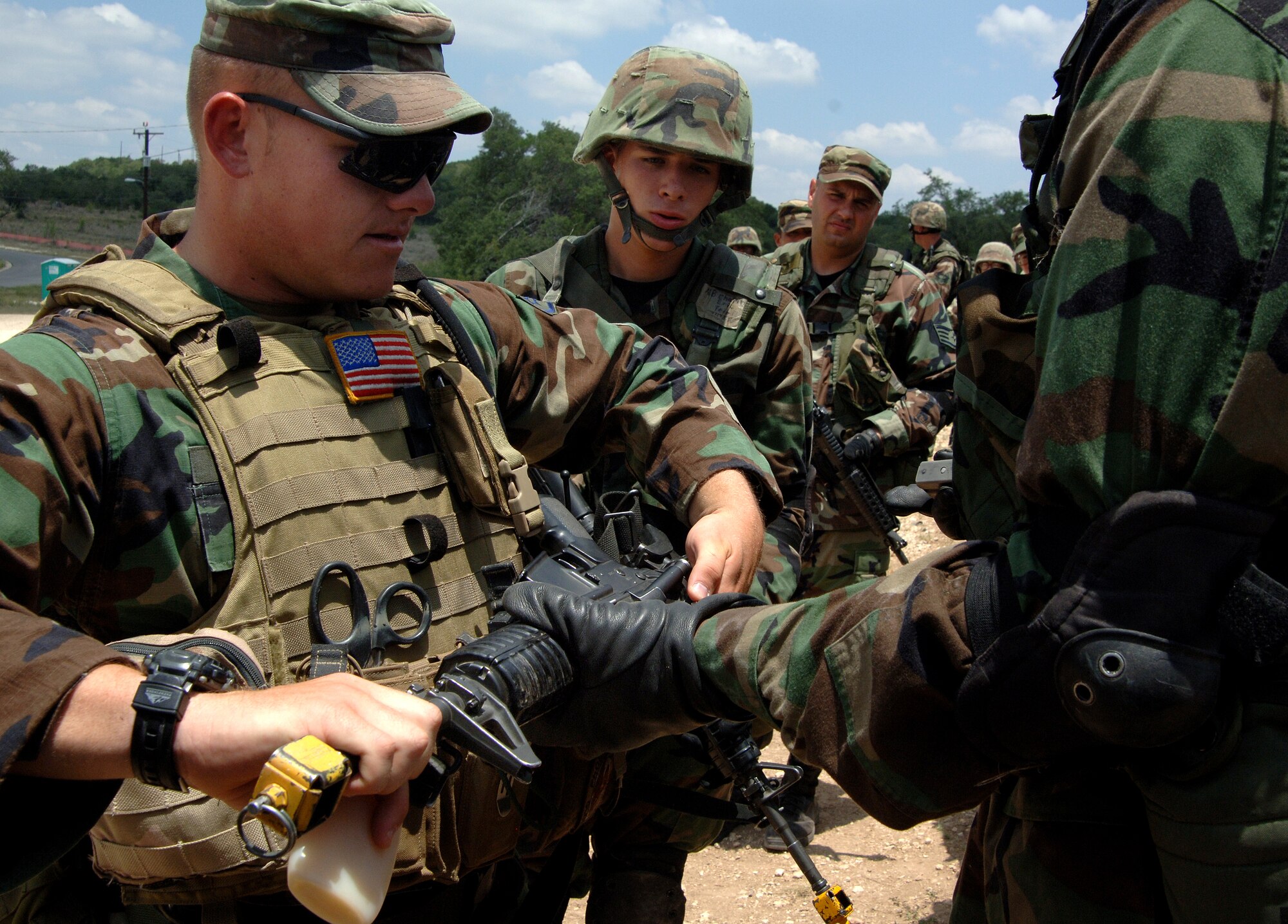 Staff Sgt. Brian Lunger, left, helps clear weapons for students during the Security Forces Academy training at Camp Bullis, Texas, on Wednesday, July 19. The 343rd Training Squadron instructs Airmen on air base defense and combat operations. Sergeant Lunger is an instructor and the NCO in charge of the military operations and urban training for the 343rd TRS. (U.S. Air Force photo/Tech. Sgt. Larry A. Simmons)