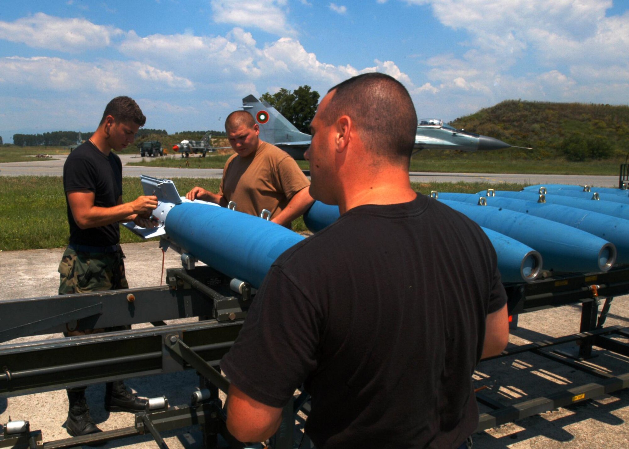 GRAF IGNATIEVO, Bulgaria- Tech. Sgt. Michael Zucco, Senior Airman Jonathan Taylor and Senior Airman Seth Roberts, 48th Munitions Squadron, prepare a GBU-12 500 pound inert bomb, with a MAU-169 computer control group, here as a MIG-29 taxis by. The MAU-169 follows a laser to the target. A laser can either be sent from the F-15E Strike Eagle or from a servicemember on the ground. The munitions troops built the bombs for the F-15 flying simulated ground attack with the Army as part of the tri-lateral exercise Immediate Response 2006, with the U.S., Bulgarian and Romanian militaries.    