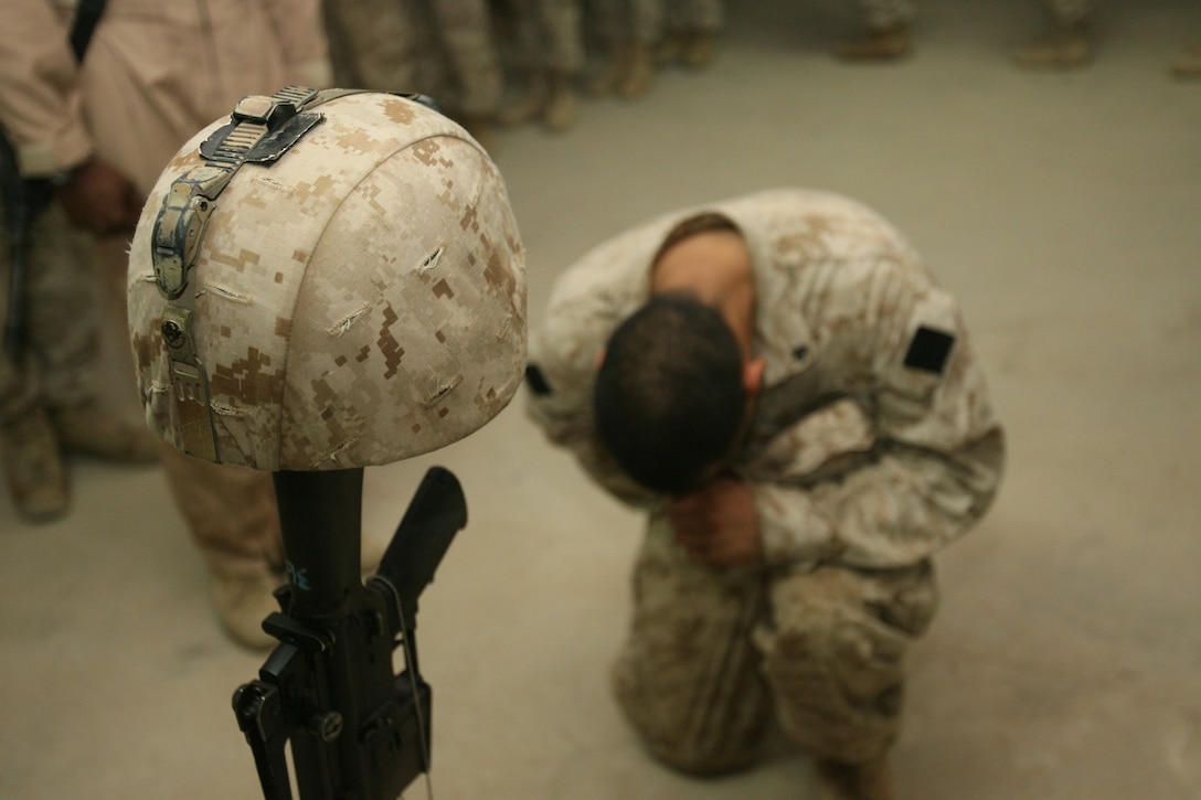 A Marine pays respect to a fallen comrade. The Camp Lejeune, N.C. - based Marines of 3rd Battalion, 8th Marine Regiment gathered at Hurricane Point to honor Cpl. Joseph A.Tomci, one of their fallen heroes, in a memorial service August 5.  Tomci was killed on August 2 while conducting combat operations against enemy forces in the Al Anbar Province. The 21-year-old from Akron, Ohio, was a squad leader in 2nd Squad, 4th Platoon, Company L, 3rd Bn., 8th Marines, which is currently deployed to Ar Ramadi, Iraq in support of Operation Iraqi Freedom.