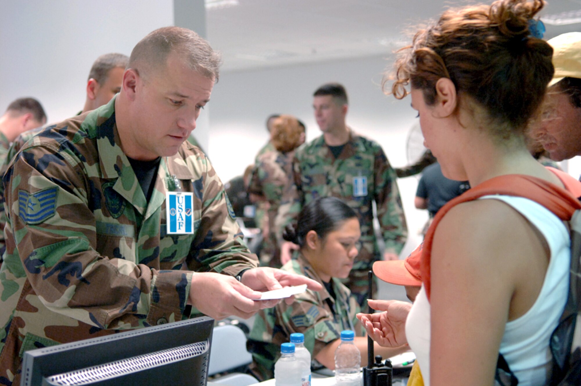 Tech. Sgt. Dave Trichel hands an American citizen who departed Lebanon the key to her temporary living quarters at Incirlik Air Base, Turkey, on July 24. Sergeant Trichel is assigned to the 39th Services Squadron. (U.S Air Force photo/Senior Airman Larry E. Reid Jr.) 
