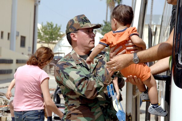 Chaplain (Maj.) Kenneth Reyes holds a toddler, one of many American citizens who departed Lebanon and arrived at Incirlik Air Base, Turkey, on July 24. Chaplain Reyes is with the 39th Air Base Wing. (U.S Air Force photo/Senior Airman Larry E. Reid Jr.)