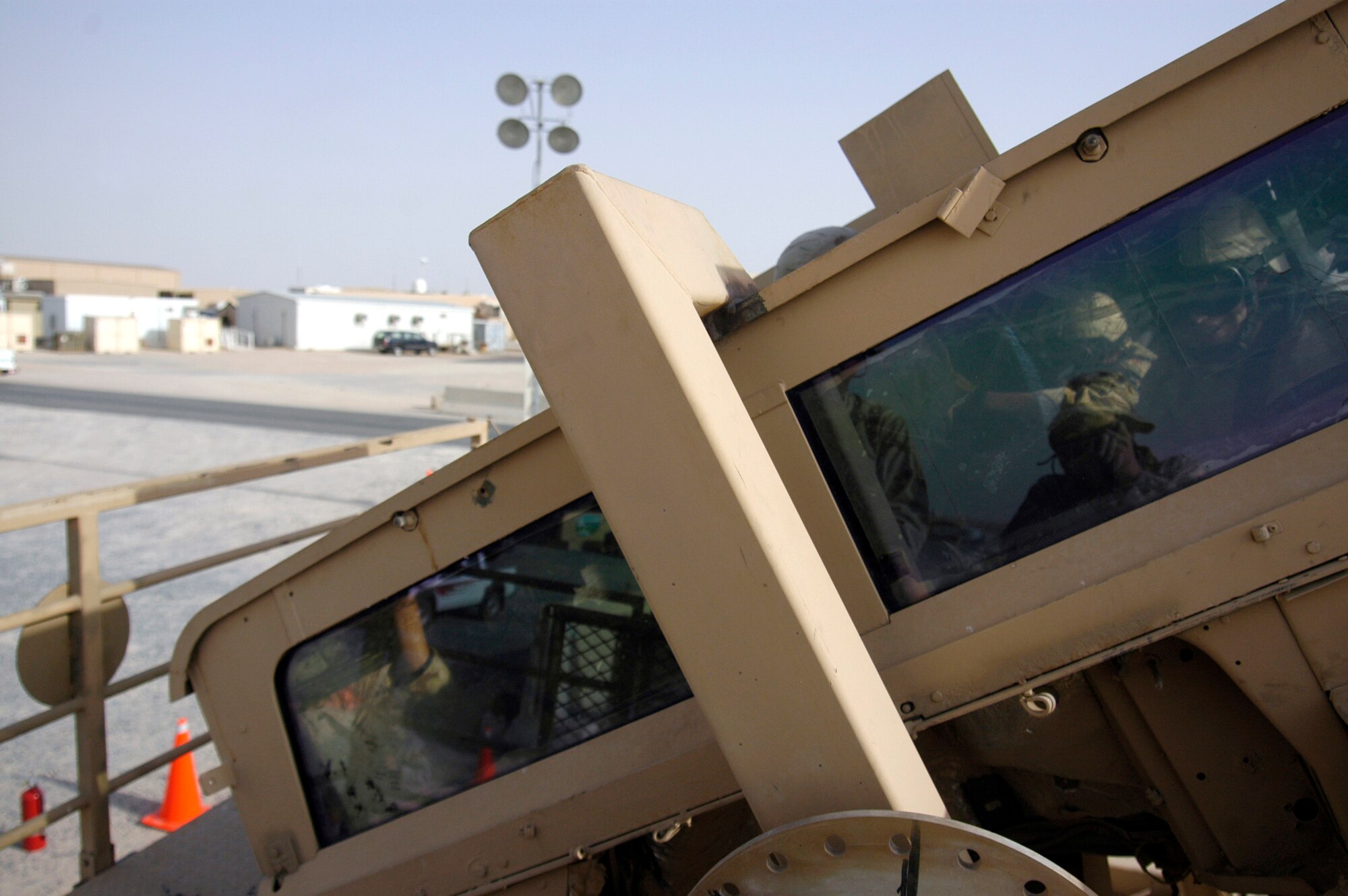 Airmen from the 386th Expeditionary Security Forces Squadron take their turn in the Humvee egress assistance trainer on July 17 at a forward operating base in Southwest Asia. The trainer, suspended six feet off the ground on a flatbed trailer, aids military members with instruction on how to escape from a Humvee that has rolled over and how to avoid such accidents. (U.S. Air Force photo/Staff Sgt. Ryan Hansen)