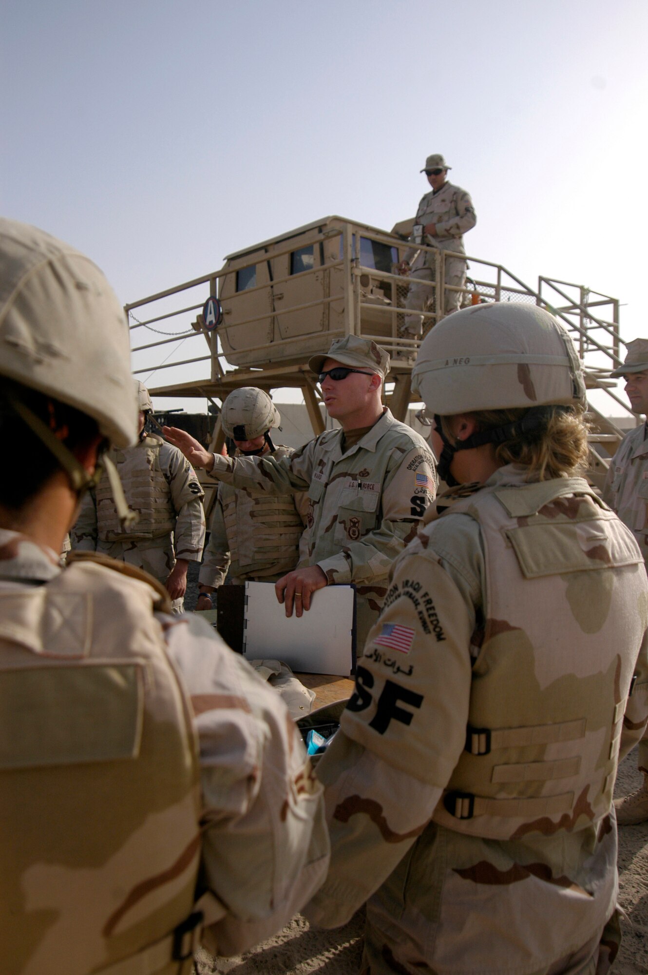 Master Sgt. John Ward instructs Airmen before they enter the Humvee egress assistance trainer July 17 at a forward operating base in Southwest Asia. The trainer aids military members with instruction on how to escape from a Humvee that has rolled over and how to avoid such accidents. Sergeant Ward is the NCO in charge of training for the 386th Expeditionary Security Forces Squadron. (U.S. Air Force photo/Staff Sgt. Ryan Hansen) 