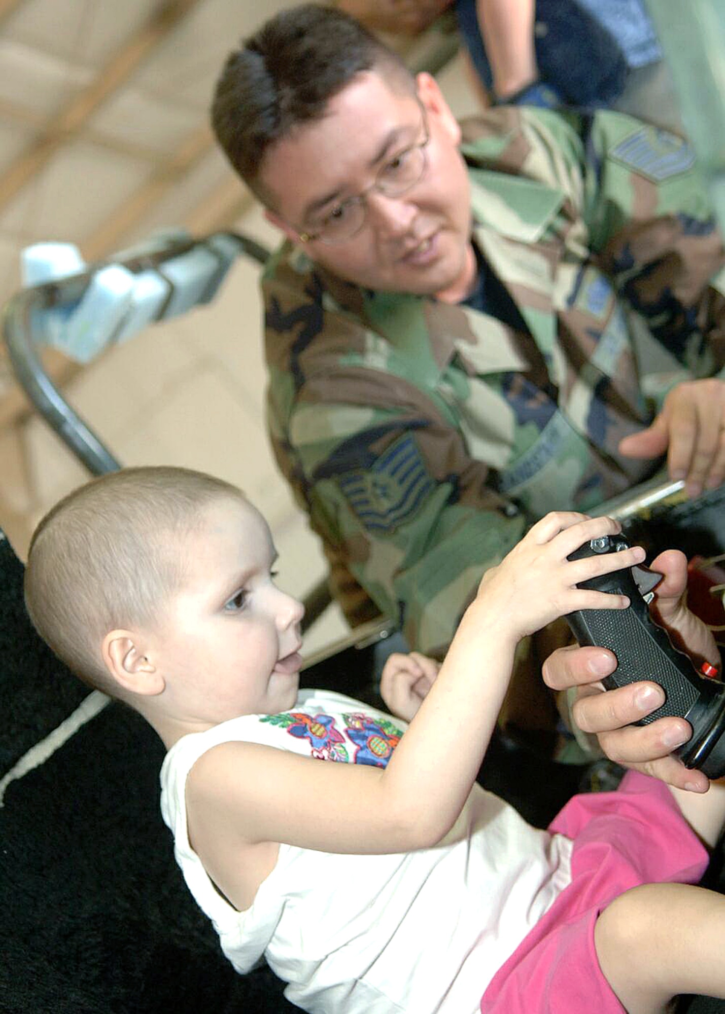 Tech. Sgt. Thomas Grandstaff shows 3-year-old Hannah Holguin the inside of the cockpit of an A-10 Thunderbolt II during a tour of Davis-Monthan Air Force Base, Ariz., on July 17. The Make-A-Wish Foundation teamed with Davis-Monthan to offer a tour of the base for Hannah and other Make-A-Wish children as well as their families. The tour consisted of demonstrations by an explosive ordnance disposal robot, base fire department and a weapons load crew for an A-10. Hannah is the daughter of Mark and Amy Holguin. Sergeant Grandstaff is with the 355th Maintenance Group. (U.S. Air Force photo/Senior Airman Christina D. Ponte)