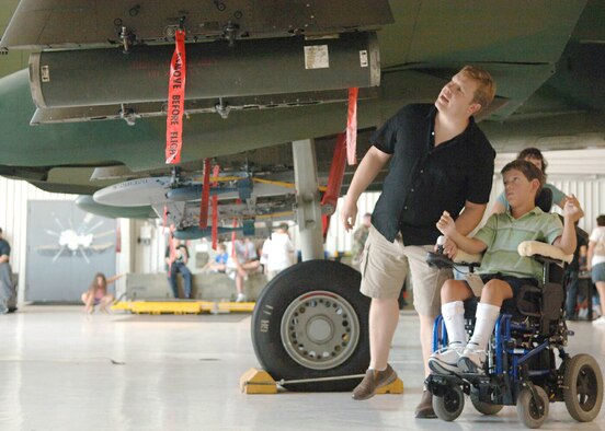 Steve Sayre and his son, Jacob, look at an A-10 Thunderbolt II during a tour of Davis-Monthan Air Force Base, Ariz., on July 17. The Make-A-Wish Foundation teamed with Davis-Monthan to offer a tour of the base for Jacob and other Make-A-Wish children as well as their families. The tour consisted of demonstrations by an explosive ordnance disposal robot, base fire department and a weapons load crew for an A-10. (U.S. Air Force photo/Senior Airman Christina D. Ponte)